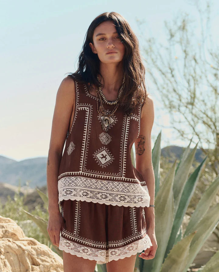 Woman wearing a patterned outfit with desert landscape in the background