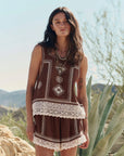 Woman wearing a patterned outfit with desert landscape in the background