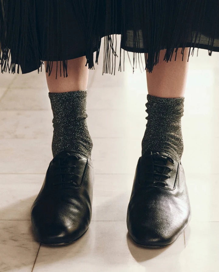 The Lurex Sock in Golden front view on model paired with black shoes