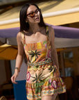 model wearing the april print romper with sunglasses and a colorful background