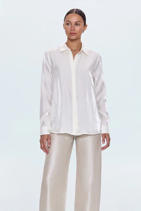 Woman wearing a white shirt and beige pants on a light blue background