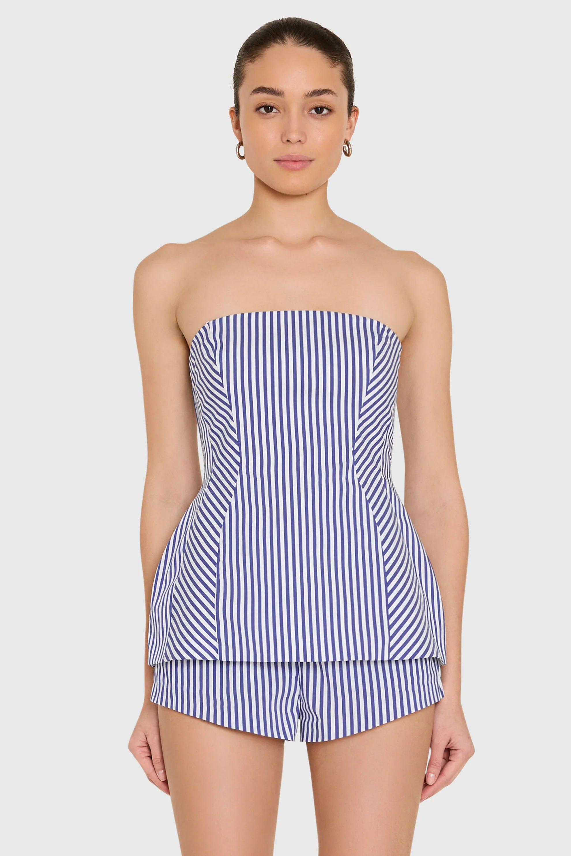 model wearing a strapless top and short set in blue and ivory stripes