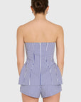 model wearing a strapless top and short set in blue and ivory stripes, back view