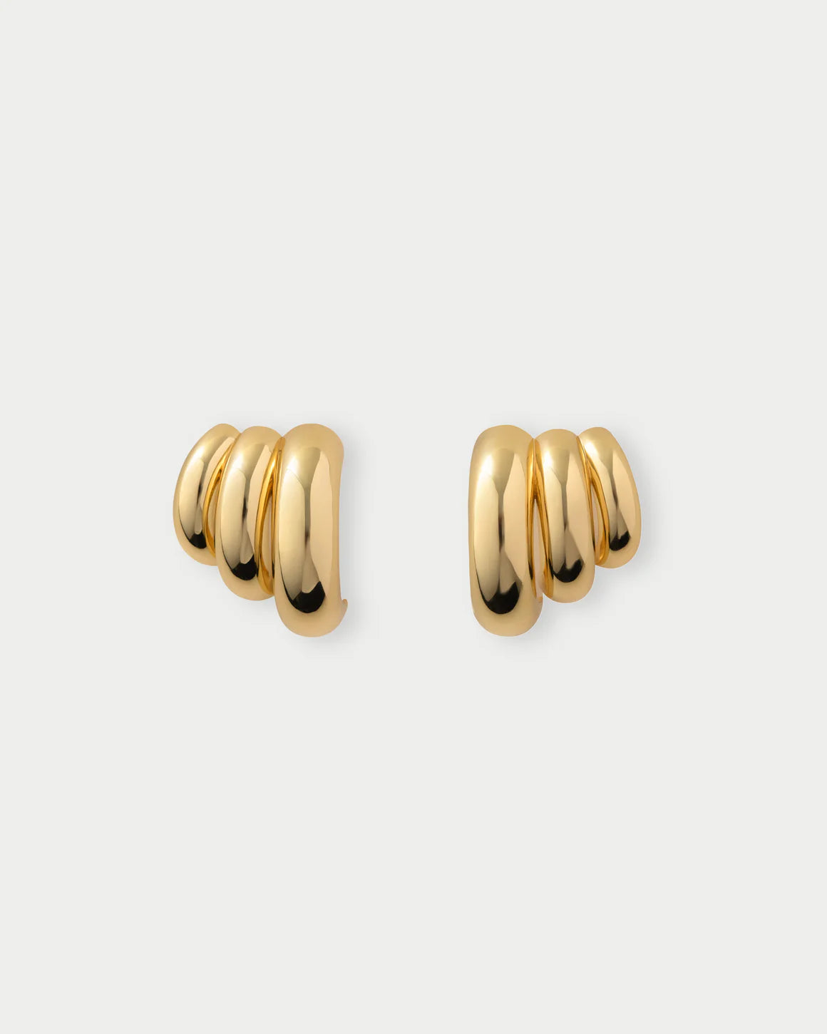 Pair of gold hoop earrings on a light gray background