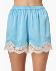 Light blue silk shorts with lace trim on a white background