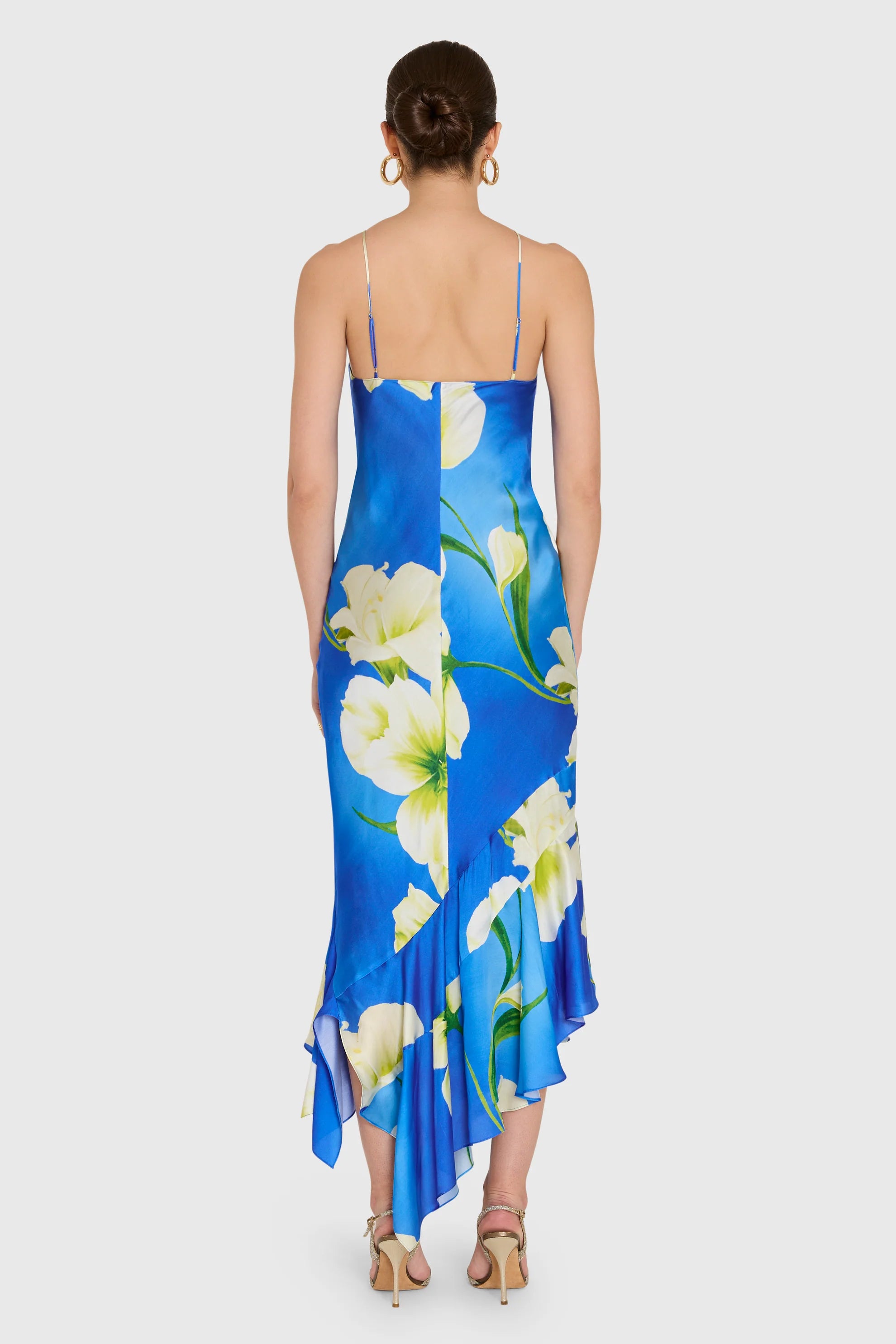 model wearing a blue dress with white flowers on a white background, back view