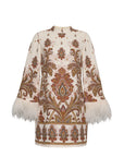 An embroidered cream-colored tunic top featuring intricate brown, gold, and teal paisley patterns, with white feather trim at the flared cuffs and a matching embroidered hem.