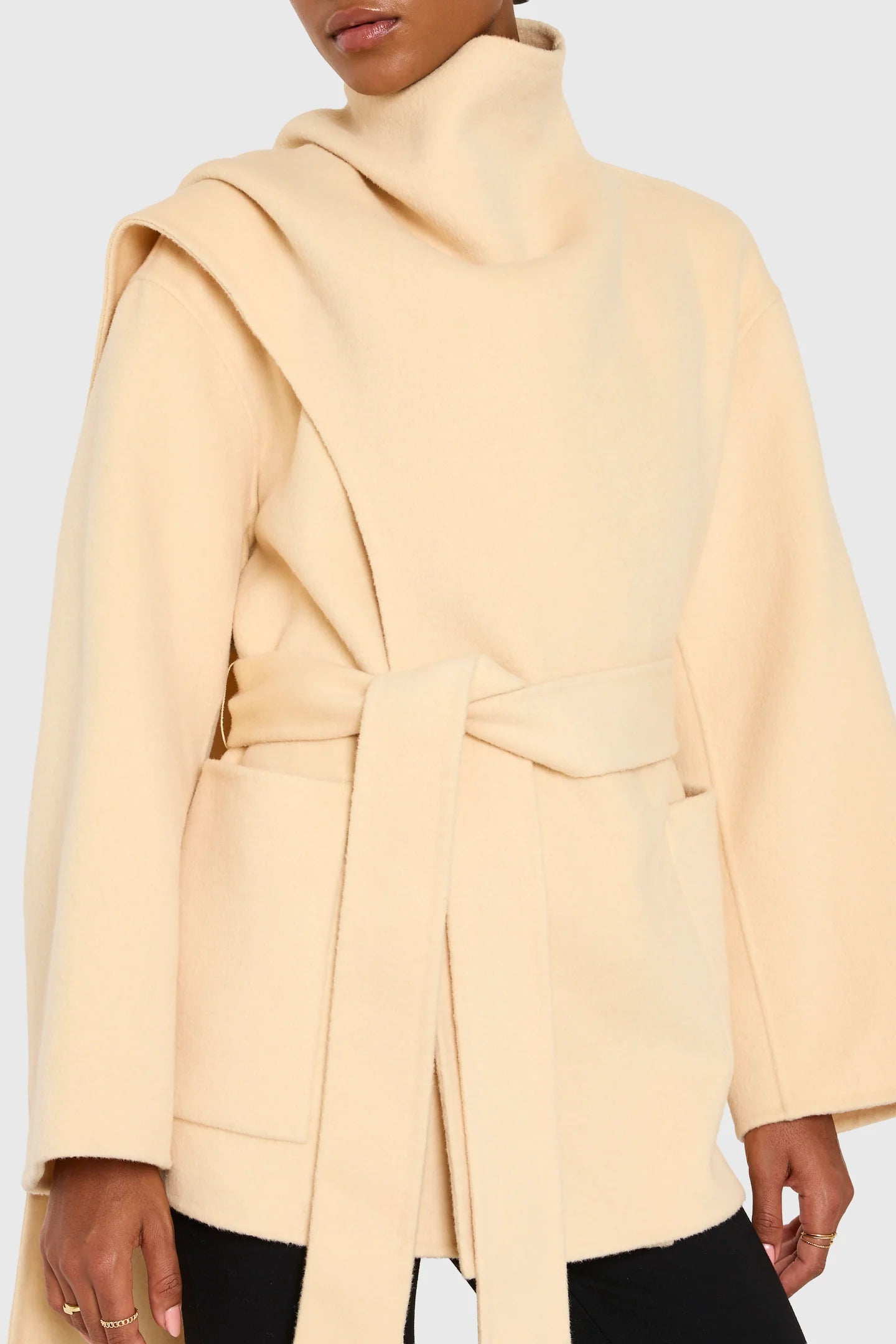 Beige coat worn by a person on a white background Woman wearing a light yellow coat against a beige background front view