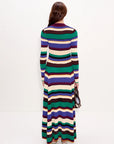 Woman wearing a long, multicolored striped dress on a white background