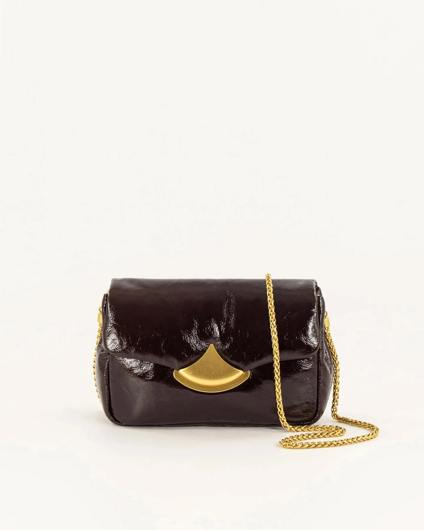 A dark brown patent leather shoulder bag with a gold-tone fan-shaped clasp and a gold chain strap, photographed on a clean white background.
