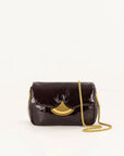 A dark brown patent leather shoulder bag with a gold-tone fan-shaped clasp and a gold chain strap, photographed on a clean white background.