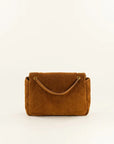 A brown suede handbag with a top handle and gold-tone hardware, photographed against a plain off-white background.