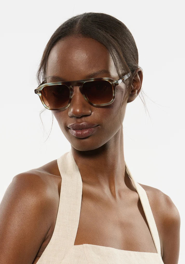 Woman wearing sunglasses with a plain background