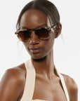 Woman wearing sunglasses with a plain background