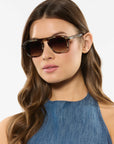 Woman wearing sunglasses with a plain background
