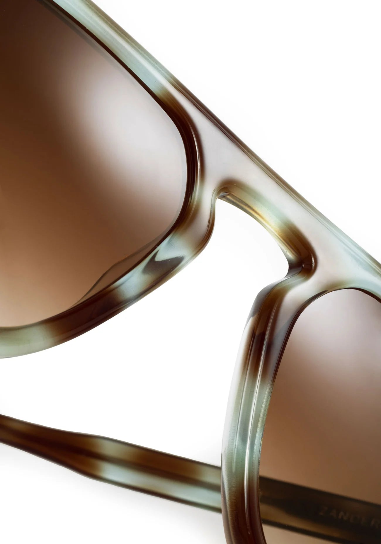 Close-up of a pair of sunglasses with tortoiseshell frame and brown lenses on a white background.