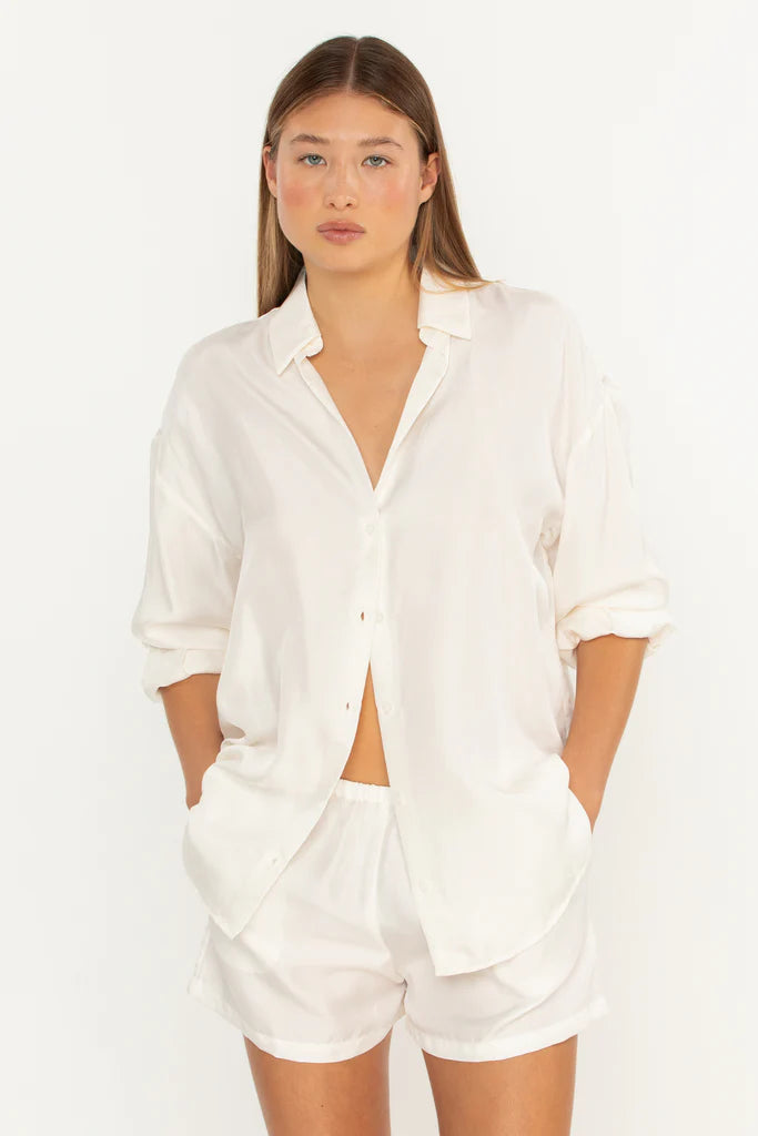 Woman wearing a white shirt and shorts set on a white background