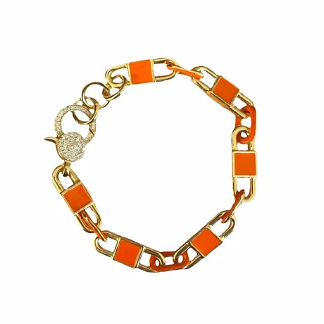 A gold-tone chain link bracelet with bright orange rectangular enamel inlays and a sparkling crystal-encrusted clasp, shown on a plain white background.