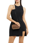 Woman wearing a black dress holding a brown handbag on a white background