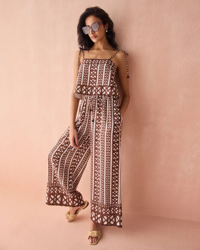 Woman wearing a patterned set against a pink background