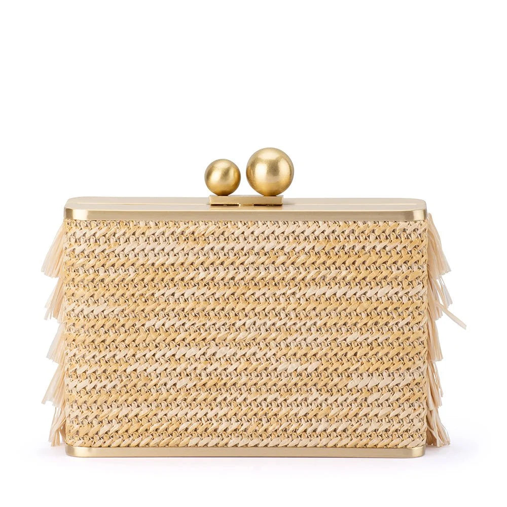 A rectangular woven clutch bag in a textured gold and beige pattern, featuring a gold metal frame, two gold spherical clasp knobs, and delicate fringe details along the sides, set against a plain white background.