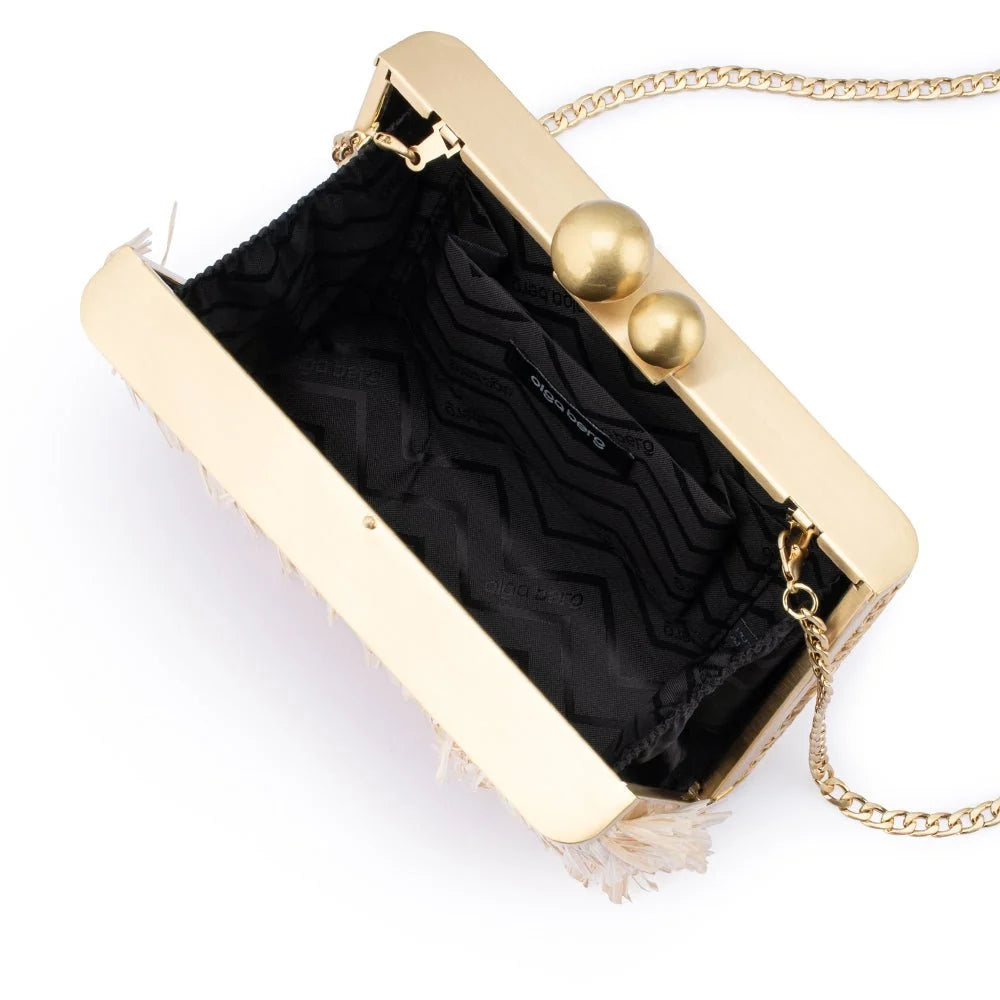 A gold-tone clutch bag with a black patterned lining, featuring two spherical gold clasp buttons and a gold chain strap, shown on a white background.