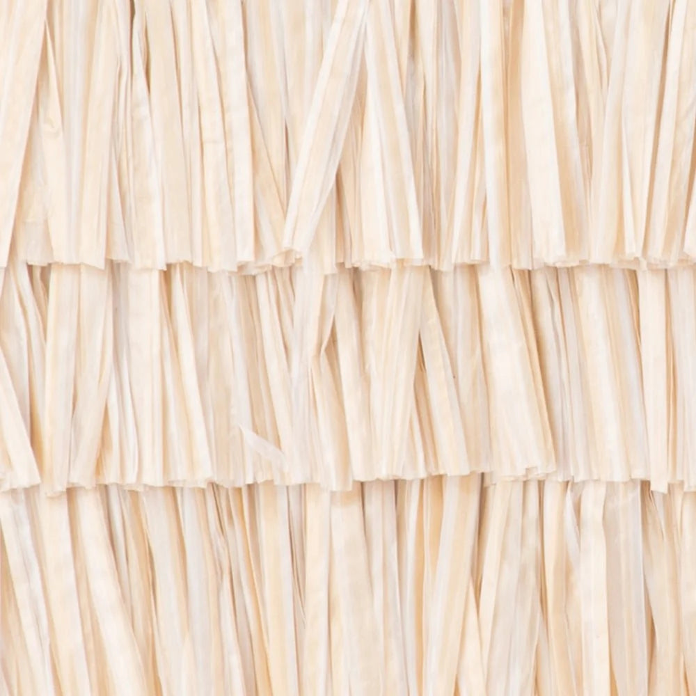A close-up of a beige raffia bag  showing the layered, frayed texture of the material.