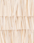 A close-up of a beige raffia bag  showing the layered, frayed texture of the material.
