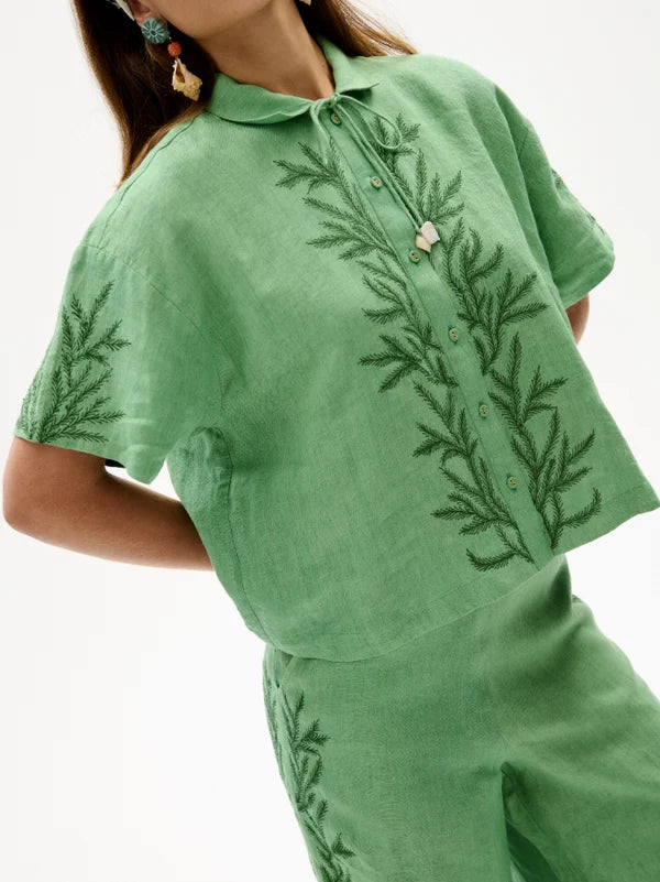 Green embroidered shirt and pants on a white background