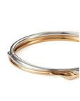 A two-tone metal bangle bracelet with a polished silver outer band and a gold inner band, shown on a clean white background.