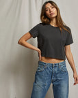model wearing cher short sleeve vintage black tee with jeans on a cream background