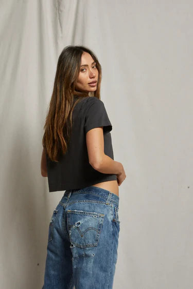 model wearing cher short sleeve vintage black tee with jeans on a cream background
