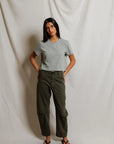 model wearing a heather grey t shirt and green pants on a white background