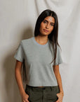 model wearing a heather grey t shirt and green pants on a white background