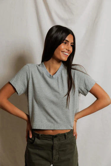model wearing a heather grey t shirt and green pants on a white background