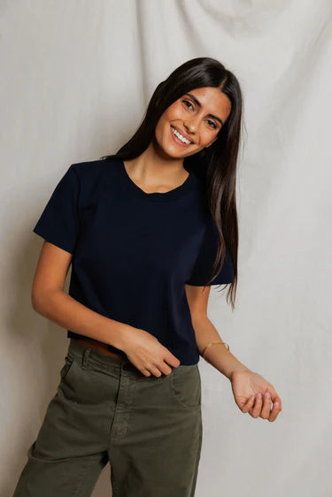 Cher Navy short sleeve tee on a model with green pants and a cream background