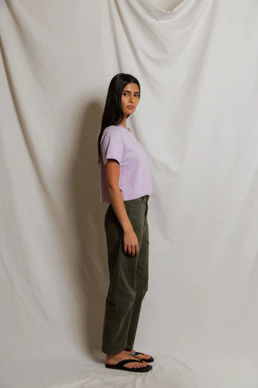 model wearing a purple tee and green pants on a white background, side view
