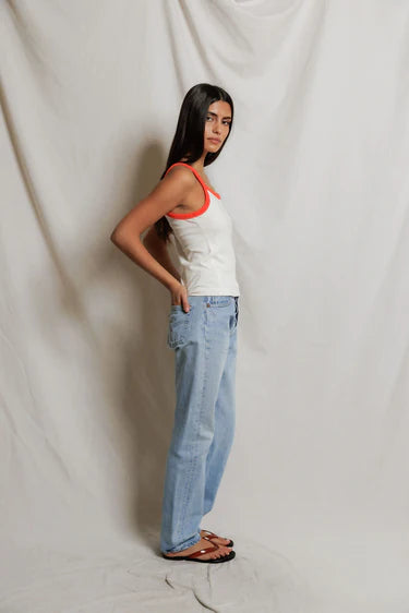 model wearing a tank and jeans  against a white background