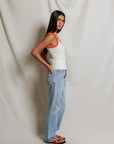 model wearing a tank and jeans  against a white background