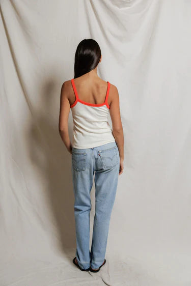 model wearing a tank and jeans  against a white background, back view