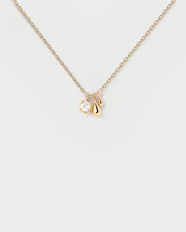 Gold necklace with a small pendant on a light gray background