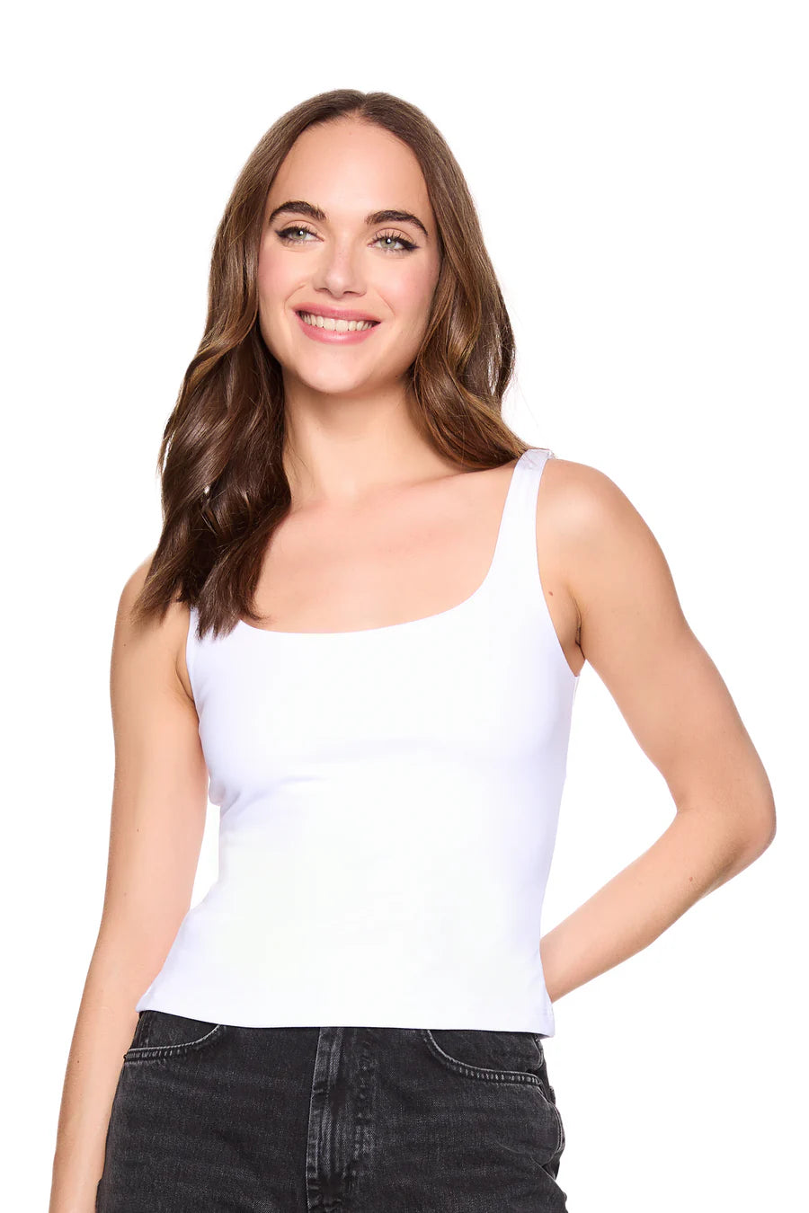 Woman wearing a white tank top and black pants on a white background