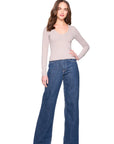 vneck long sleeve top in sandstone on a model wearing jeans with a white background