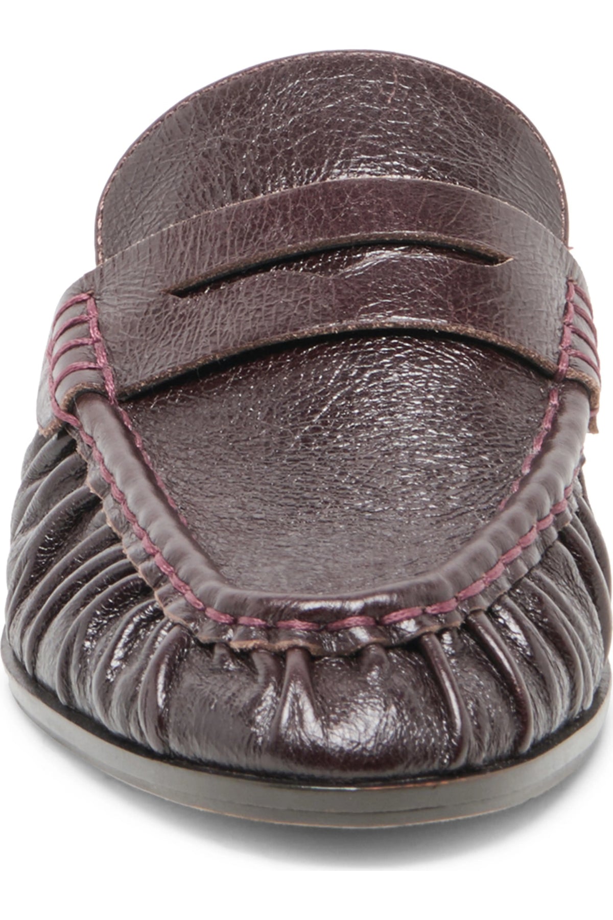 A close-up of a dark brown leather moccasin loafer with a textured leather strap and gathered footbed, featuring pink contrast stitching.