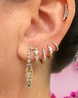 Single Tiny Pave Hoop on model's ear with a bunch of other earrings