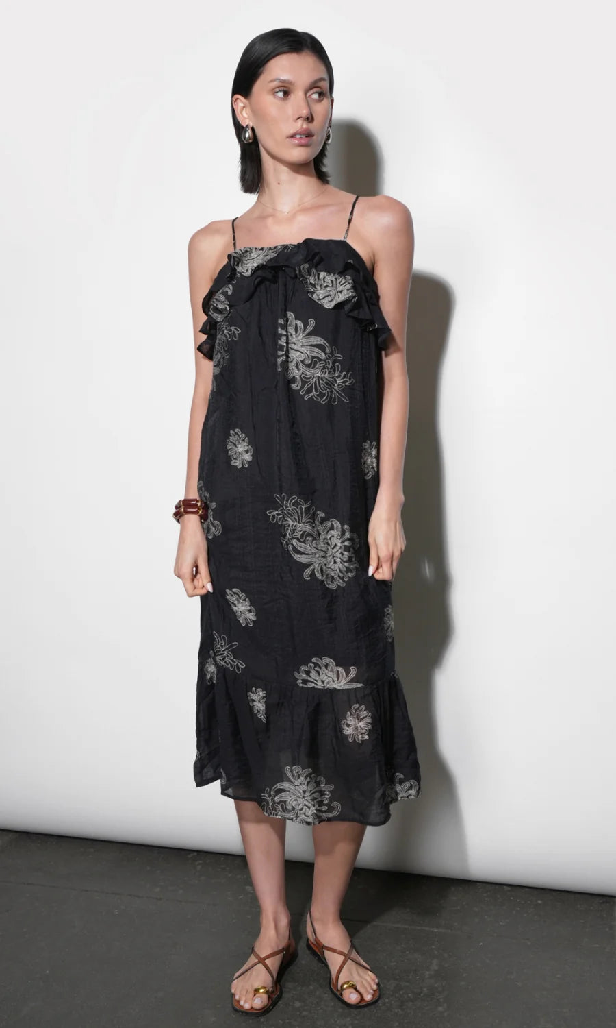 model wearing the Paige Layered Ruffle Midi Dress with strappy sandals on a white background, front 