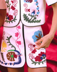 Embroidered outfit with colorful floral designs on a red background