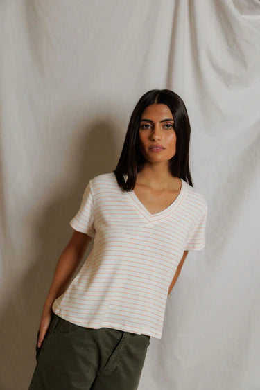 Woman wearing a white striped shirt against a plain background