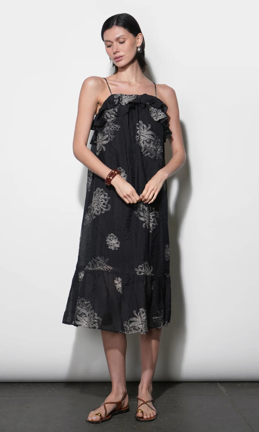 model wearing the Paige Layered Ruffle Midi Dress with strappy sandals on a white background, front 