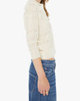 Woman wearing a light-colored blouse and blue jeans on a white background